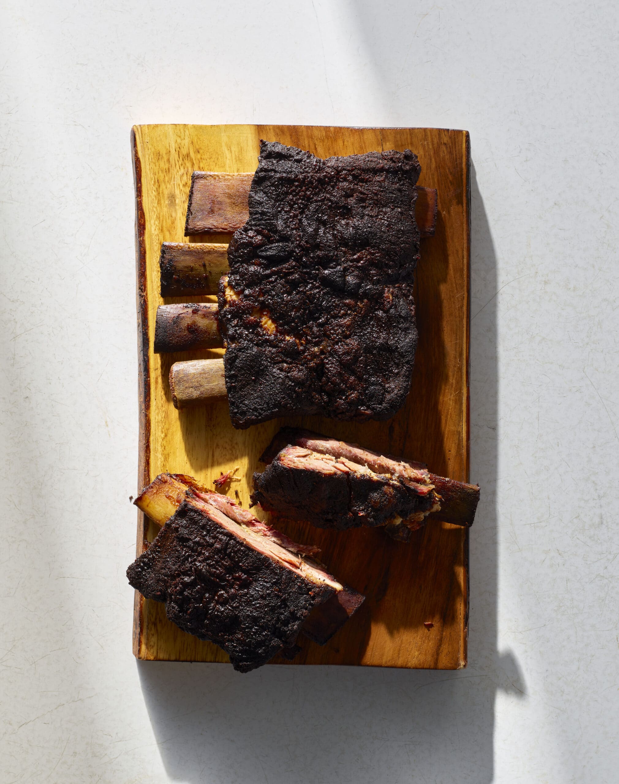 Tender smoked beef ribs with bark, sliced and plated for serving.