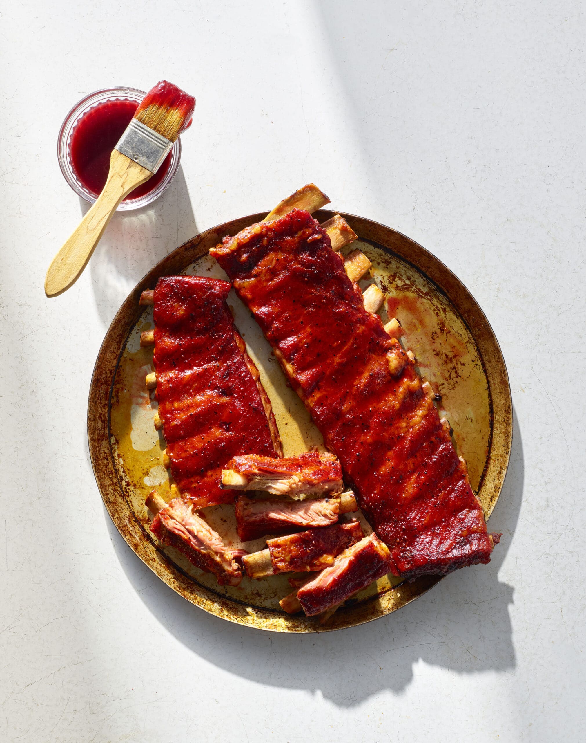 Rack of smoked ribs glazed with blackberry BBQ sauce and sliced for serving.