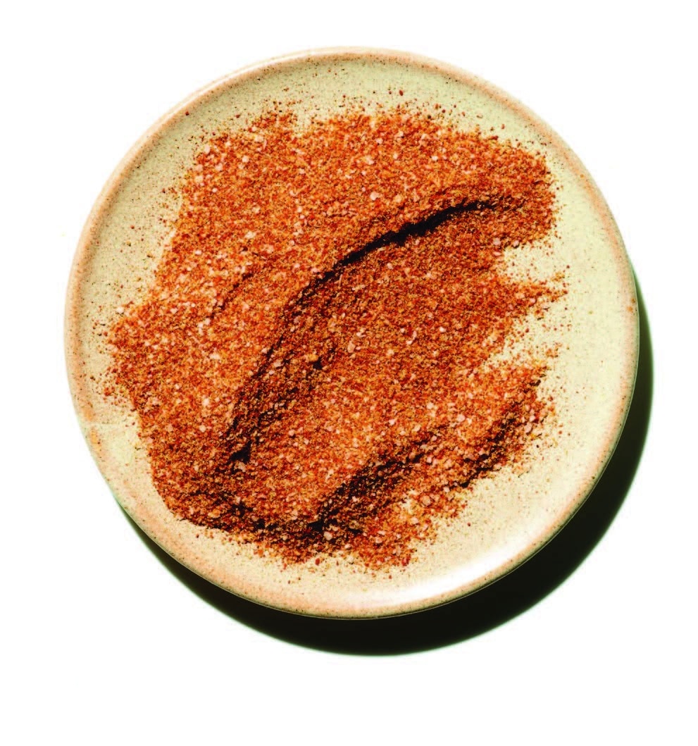 Basic chicken rub mixture in a small bowl with a rustic background.