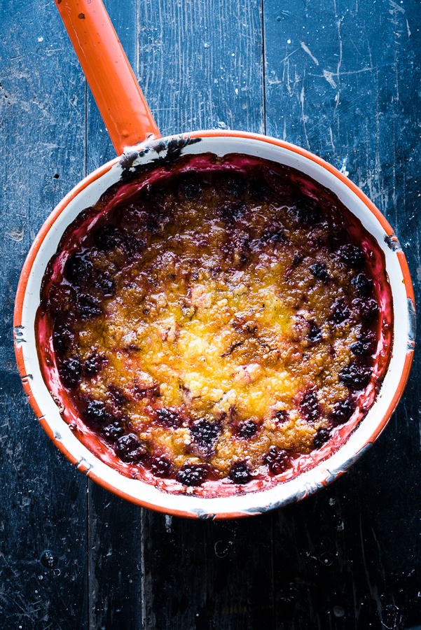 Smoky blackberry cobbler in foil pan with golden cookie topping