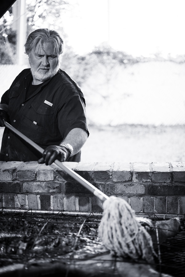 Myron Mixon's pit mop in a pot with steam rising and lemon halves floating