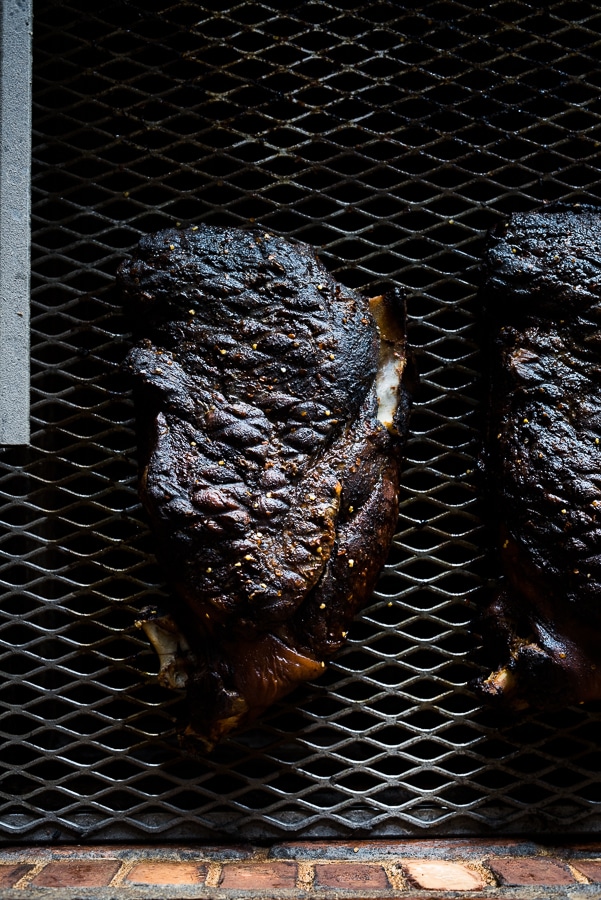Smoked pork shoulder on a cutting board with bark and smoke ring