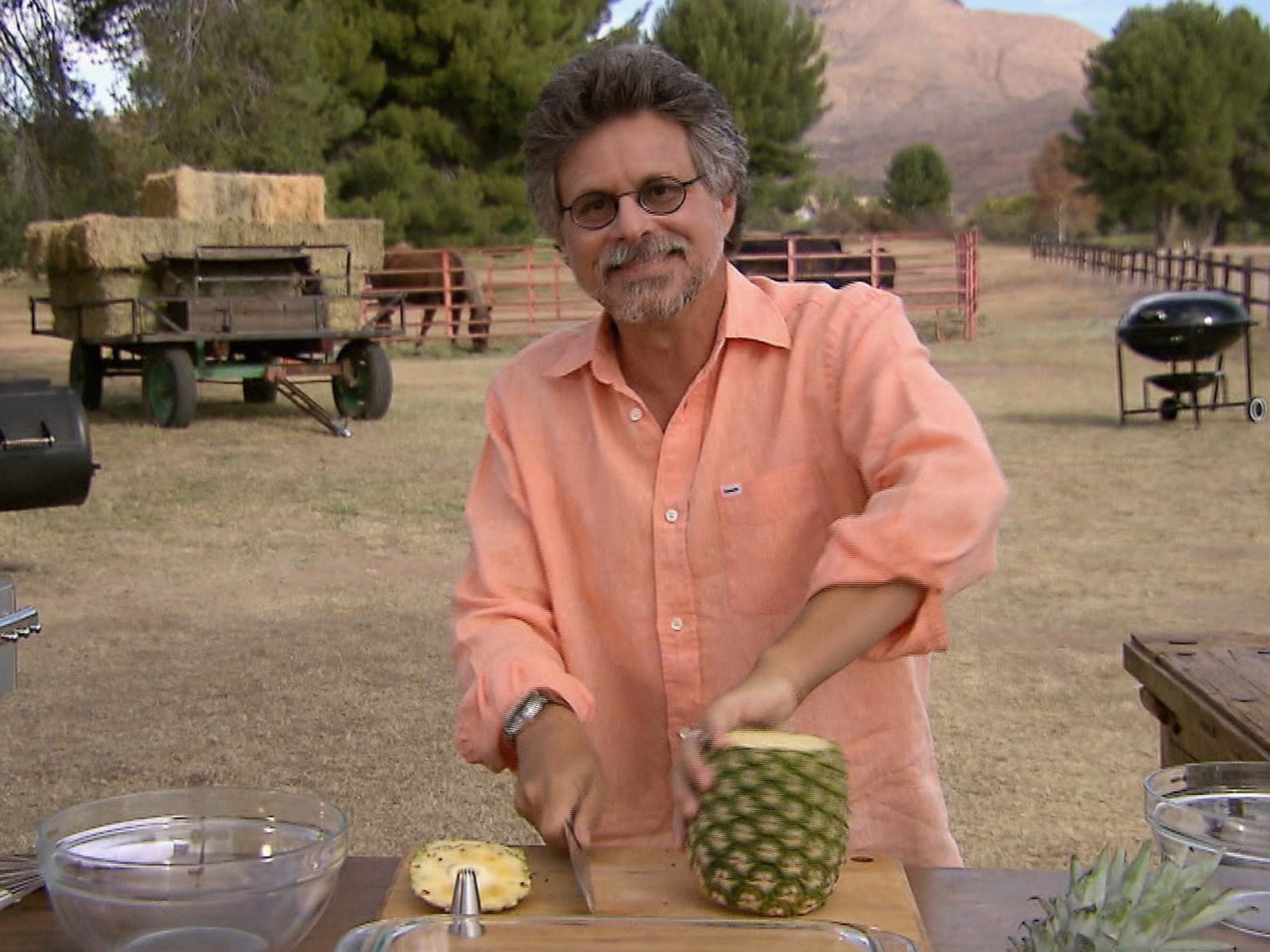 Rotisserie-grilled pineapple with caramelized cinnamon sugar crust, roasting over open flames.