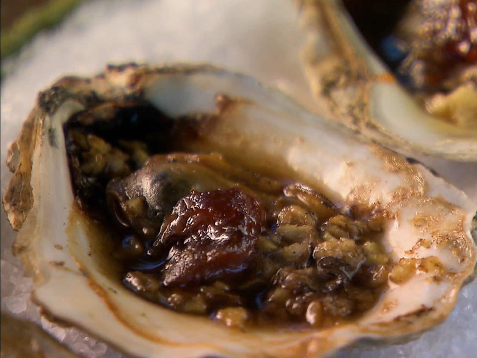 Grilled Belgian oysters on the half shell with herbed butter and lemon wedges