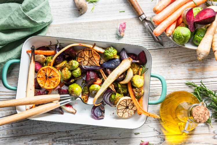 Charred Brussels sprouts, carrots, beets, and roasted garlic in a cast iron skillet