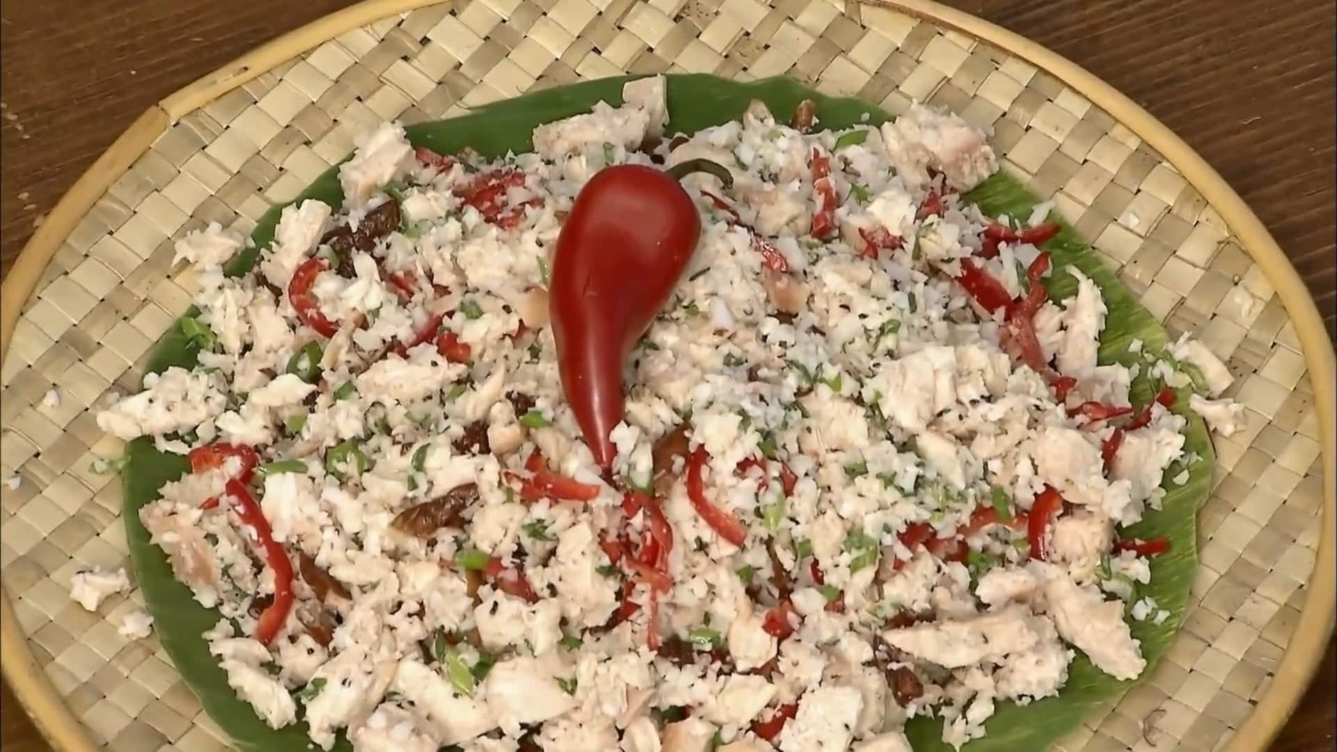 Guamian smoked chicken salad with vegetables and coconut dressing on a banana leaf