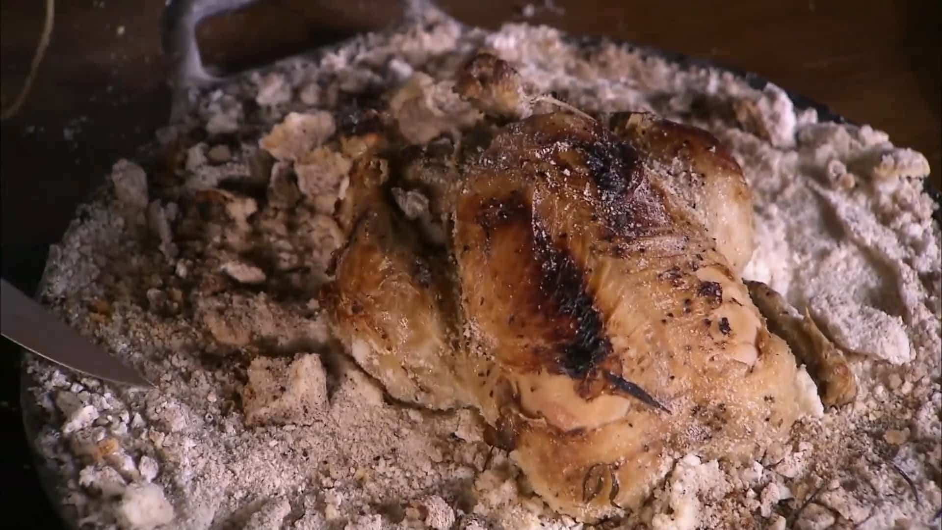 Salt-crusted gaucho-style whole chicken roasted over fire with grilled vegetables