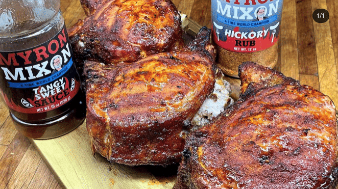 Apple and sausage stuffed pork chops plated with green beans, peppers, and onions.