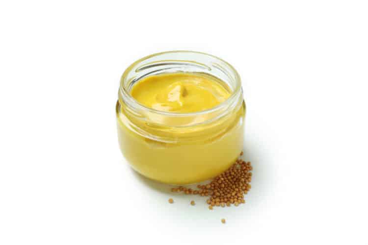 Bowl of creamy orange-mayo sandwich sauce with orange zest garnish