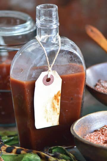 Pineapple barbecue sauce in a glass jar with fresh pineapple and chiles