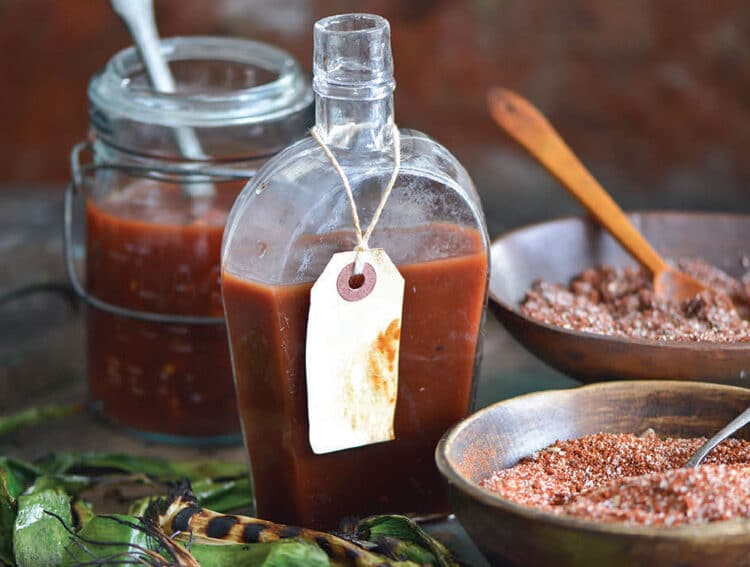 Pineapple barbecue sauce in a glass jar with fresh pineapple and chiles