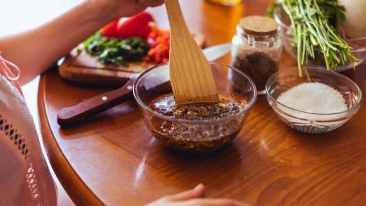 Dark beef marinade in a measuring cup with injector tool beside it.