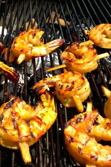 Grilled shrimp skewers glazed with rum and brown sugar on sugarcane sticks