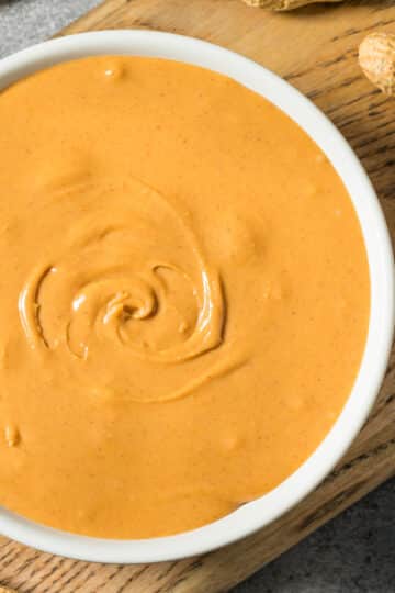 Rich and creamy Singapore peanut sauce in a bowl, topped with fried garlic slices