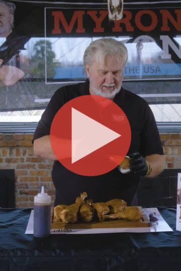 BBQ Pitmaster Myron Mixon preparing turkey legs with a smoker in the background