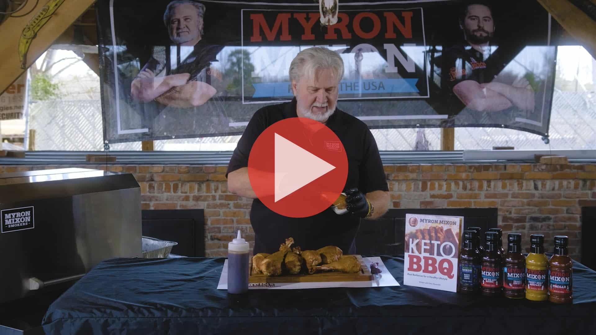 BBQ Pitmaster Myron Mixon preparing turkey legs with a smoker in the background
