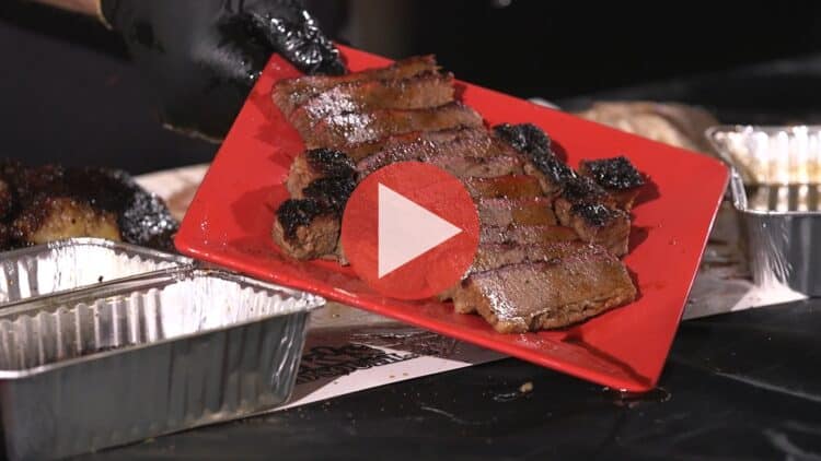 BBQ Pitmaster Myron Mixon trimming a large Wagyu brisket on his prep table