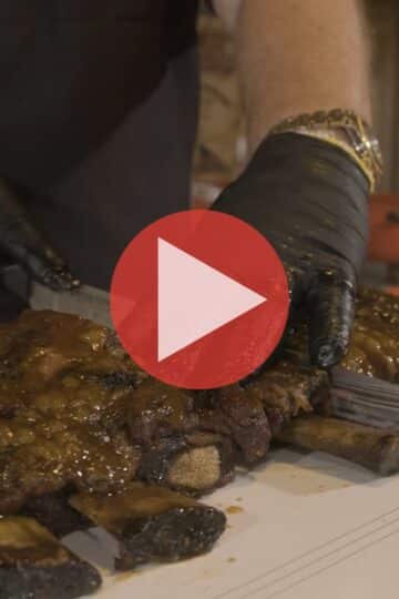 BBQ Pitmaster Myron Mixon injecting and seasoning a slab of beef short ribs at the BBQ pavilion