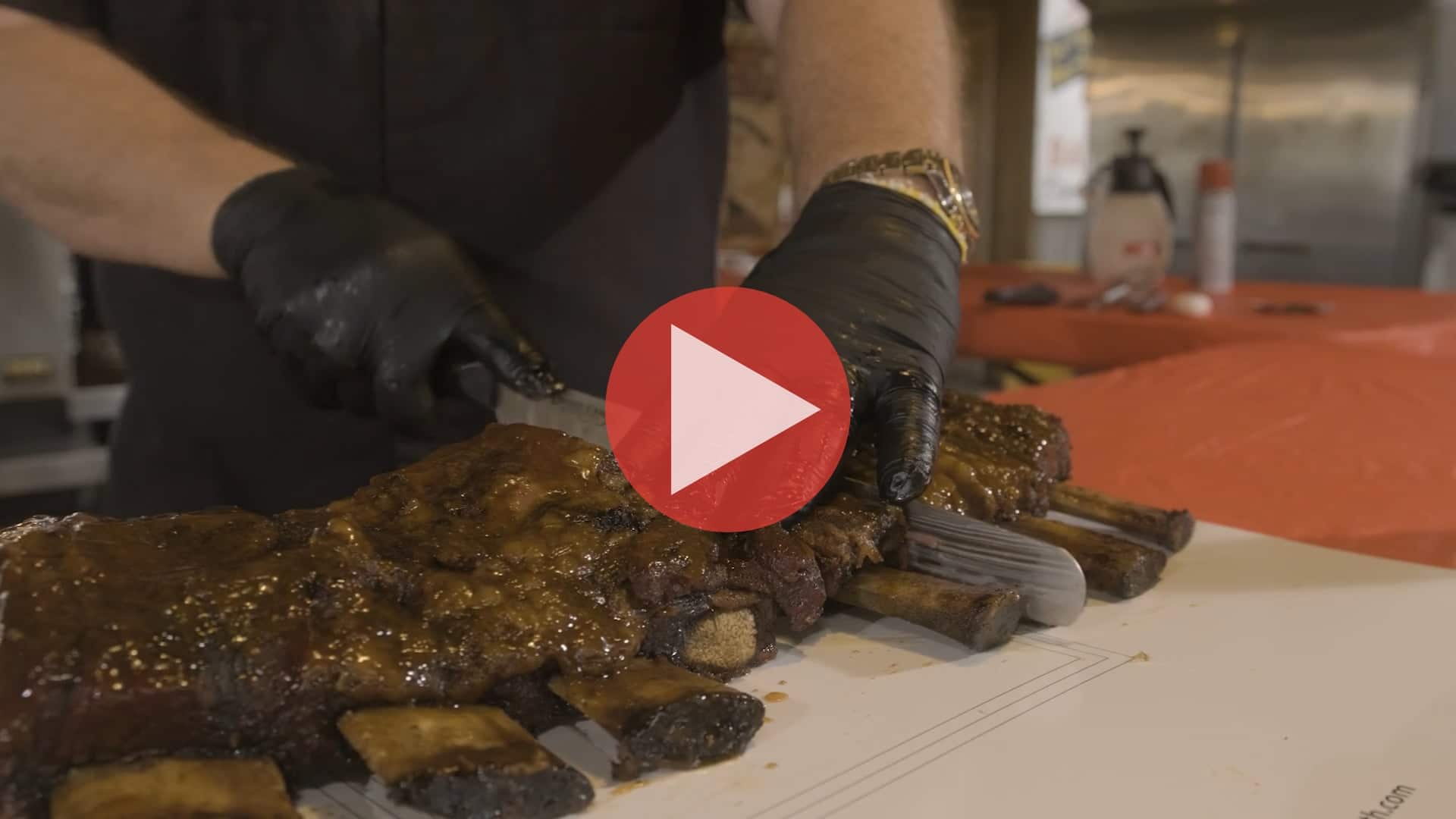 BBQ Pitmaster Myron Mixon injecting and seasoning a slab of beef short ribs at the BBQ pavilion
