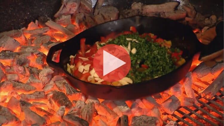 Steven Raichlen cooking over open fire in Primal Grill