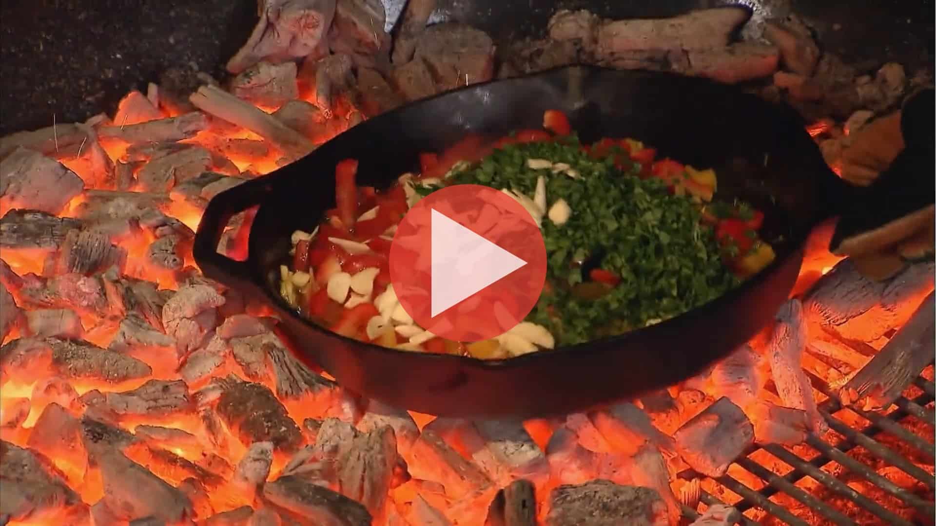 Steven Raichlen cooking over open fire in Primal Grill