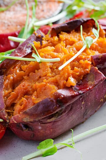 Slow-smoked sweet potato sliced open with butter melting inside