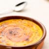 Dish of creamy Catalan dessert custard garnished with lemon zest.