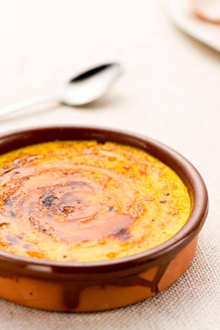Dish of creamy Catalan dessert custard garnished with lemon zest.
