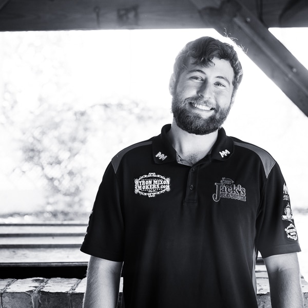 Michael Mixon standing confidently near a smoker, embodying the next generation of championship BBQ